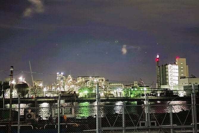 Industrial plants lit up on the far shore of a canal at night